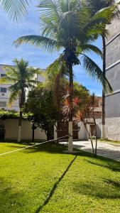 two palm trees in a yard with a building at Studio de Hóspedes - 150m da Praia in Rio de Janeiro
