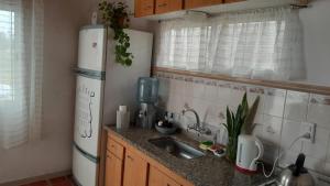 a kitchen with a sink and a refrigerator at La Goldie in Concepción del Uruguay