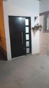 a black door in a room with a concrete floor at La Goldie in Concepción del Uruguay