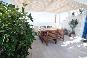 a patio with a wooden table and a potted plant at Vico Lungo 9, Peschici in Peschici +30 photos