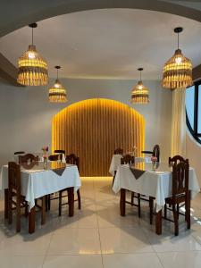 a restaurant with tables and chairs and a yellow wall at Valle Hermoso in San Ramón