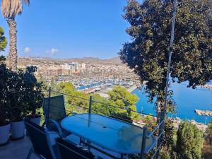 a table and chairs on a balcony overlooking a harbor at The sea-cave house in Puerto de Mazarrón