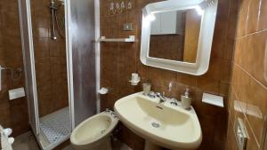 a bathroom with a sink and a toilet and a mirror at Tre Archi Sea Home in Lido di Fermo +6 photos