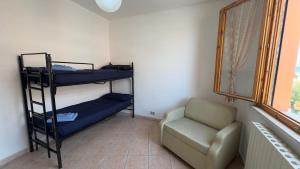 a room with two bunk beds and a chair at Tre Archi Sea Home in Lido di Fermo