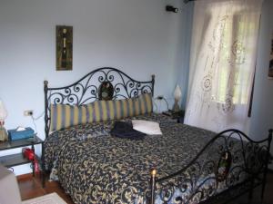 a bedroom with a bed with a black and white comforter at Villa Vallevento in Calamandrana