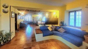 a living room with a blue couch in a room at Villa Vallevento in Calamandrana