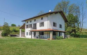 a large white house with a grass yard at Villa Vallevento in Calamandrana