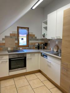 a kitchen with white cabinets and a stove top oven at Reitterhof in Laufnitzdorf in Frohnleiten