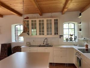 a kitchen with white cabinets and a sink at Fårhuset at Åkarp in Trelleborg