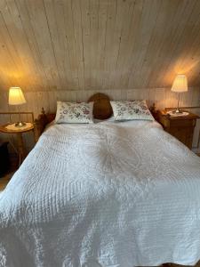 a bedroom with a large white bed with two lamps at Fårhuset at Åkarp in Trelleborg