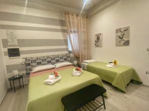 two beds in a room with green and pink at Regina Claudia in Garaguso