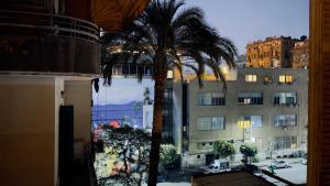 a palm tree in front of a building at Stay Ra3 Suites in Cairo