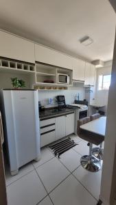 a kitchen with a refrigerator and a table in it at Apartamento no Cond Vinhedos in Petrolina