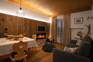 a living room with a table and a fireplace at Binterhof Alpin Deluxe APP in Castelrotto