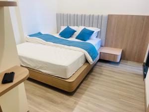 a bedroom with a bed with blue pillows at Đô thị Vinhomes Grand Park in Gò Công