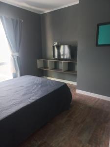 a bedroom with a bed and a flat screen tv at Paramecó in Balneario Claromecó
