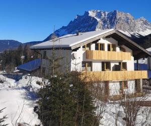 a house in the snow with mountains in the background at Haus Gerda in Biberwier