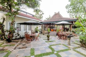 a patio with tables and chairs and umbrellas at HOME 88 Feels Like Home in Sleman +18 photos