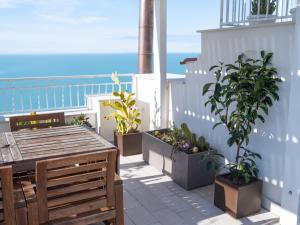 a balcony with a table and potted plants and the ocean at Vico Lungo 9, Peschici in Peschici