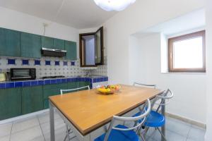 a kitchen with a wooden table and blue cabinets at Appartamenti Castello in Peschici