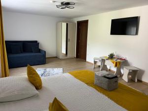 a bedroom with a large bed and a blue couch at Casa Dani&Moni in Moieciu de Sus