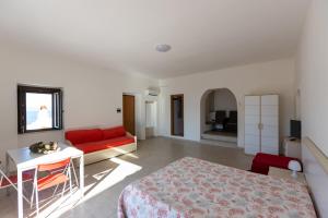 a bedroom with a bed and a table and a couch at Appartamenti Castello in Peschici