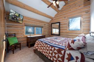 a bedroom in a log cabin with a bed and a desk at 526 Alan Rd - Durango CO. in Durango