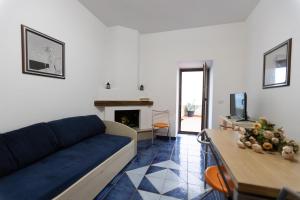 a living room with a blue couch and a fireplace at Appartamenti Castello in Peschici