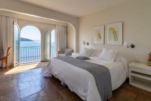 a bedroom with a large bed with a view of the ocean at Casas Brancas Boutique Hotel & Spa in Búzios +133 photos