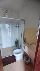 a bathroom with a shower and a toilet and a sink at Pousada Central in Montes Claros