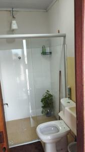 a bathroom with a toilet and a glass shower at Pousada Central in Montes Claros +3 photos