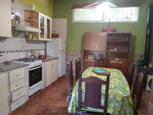 a kitchen with a table and a stove and refrigerator at Nahomi House in Barrio Félix U Camet