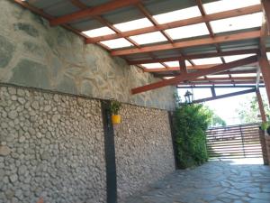 a building with a wooden roof and a stone wall at Nahomi House in Barrio Félix U Camet +5 photos