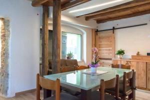 a dining room with a glass table and chairs at GIAMI affittacamere & SPA in Santa Giustina