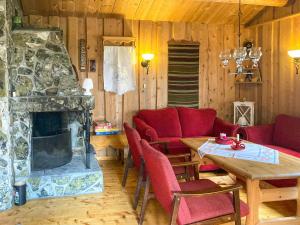 a living room with a red couch and a fireplace at Simple Mountain Cabin Near Vinstra in Vinstra