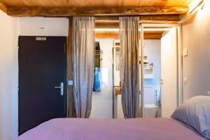 a bedroom with a bed and a door to a bathroom at GIAMI affittacamere & SPA in Santa Giustina