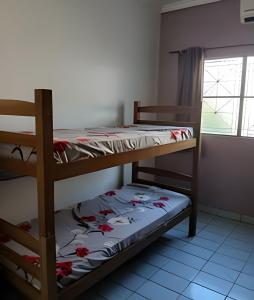 two bunk beds in a room with a window at Casa em Maceió Para Alojamento ou Família Grande in Maceió
