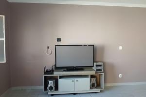 a flat screen tv sitting on a stand with speakers at Casa em Maceió Para Alojamento ou Família Grande in Maceió