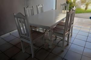 a table with four chairs and a table and a table and chairs at Casa em Maceió Para Alojamento ou Família Grande in Maceió
