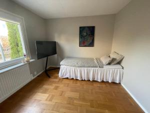 a bedroom with a bed and a flat screen tv at Hus, barnvänligt, nära strand in Halmstad