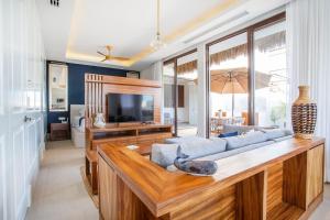 a living room with a couch and a television at Elegance - Jungle meet with private pool heated in Bucerías