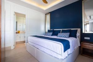 a bedroom with a large bed with blue walls at Elegance - Jungle meet with private pool heated in Bucerías +46 photos