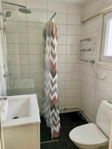 a bathroom with a shower curtain and a sink at Hus, barnvänligt, nära strand in Halmstad +6 photos