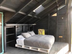 a bedroom with a large bed in a wooden room at Refugio costero Molle in Boca Pupuya