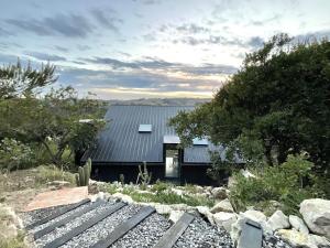 a house with a metal roof and some rocks at Refugio costero Molle in Boca Pupuya
