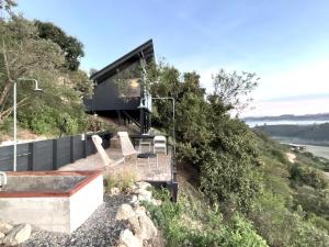 a house on the side of a hill with chairs at Refugio costero Molle in Boca Pupuya