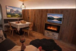 a living room with a table and a fireplace at Binterhof Alpin Deluxe APP in Castelrotto