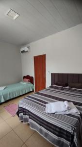 a bedroom with two beds with towels on them at Pousada Central in Montes Claros