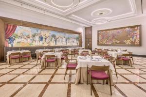a dining room with tables and chairs and a large painting at Fiesta Americana Merida in Mérida