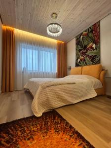 a bedroom with a large bed and a large window at Jora su terasa apartamentai in Stančiai
